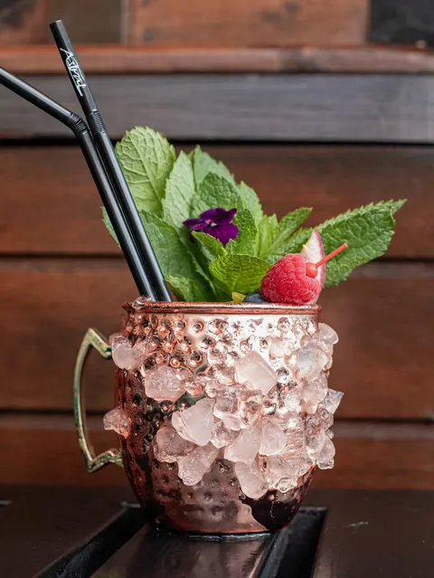 A mule served in a copper mug packed with crushed ice, mint and raspberry.