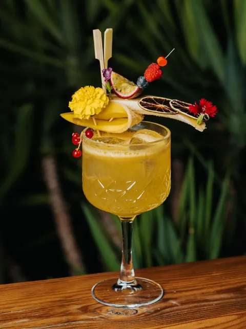 A mango cocktail in a cut-glass coupe with marigold, dried citrus and a carnation.