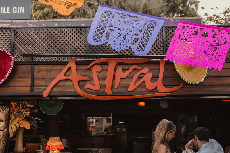 The orange Astral sign on the ship with papel picado bunting above.